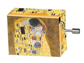 A beautifully designed music box featuring Gustav Klimt's iconic painting 'The Kiss'. The box has a vibrant golden background adorned with intricate patterns, highlighting the romantic embrace depicted in the artwork. The side of the box shows a metal winding mechanism, adding to its charm as a decorative item or a unique gift.