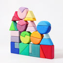A colorful wooden building set featuring various geometric shapes including triangles, squares, and circles stacked creatively. The pieces are in vibrant shades of pink, blue, green, yellow, orange, and purple, showcasing a playful arrangement that encourages imaginative play and cognitive development in children.