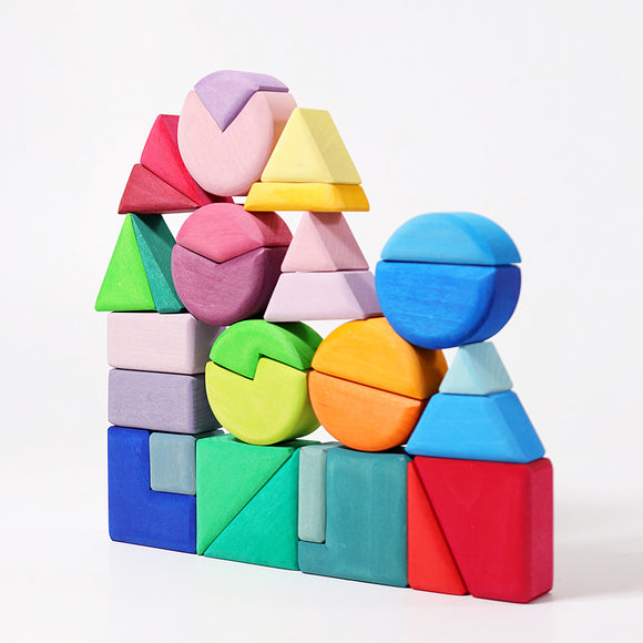 A colorful wooden building set featuring various geometric shapes including triangles, squares, and circles stacked creatively. The pieces are in vibrant shades of pink, blue, green, yellow, orange, and purple, showcasing a playful arrangement that encourages imaginative play and cognitive development in children.