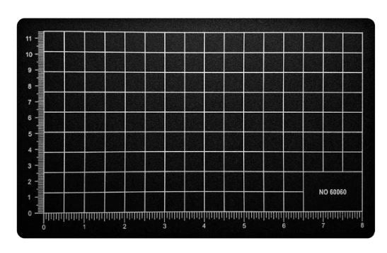 A black cutting mat measuring 5.5 inches by 9 inches, featuring a grid pattern with white lines and measurement markings along the edges, ideal for precise cutting and crafting.