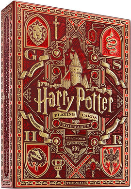 A beautifully designed box of Harry Potter playing cards in red and gold colors featuring symbols associated with Hogwarts houses. The design includes a lion for Gryffindor, a snake for Slytherin, and a badger for Hufflepuff, along with intricate patterns and the iconic Hogwarts castle. The title 'Harry Potter' is prominently displayed at the top, making it a perfect collectible for fans of the series.