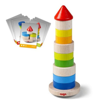 The Stacking Game Wobbly Tower by Haba features colorful wooden discs in blue, green, yellow, and red, stacked to form a tower. The game includes challenge cards to guide the stacking process, encouraging creativity and fine motor skills development.