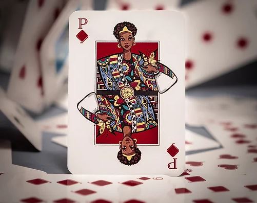 The Playing Fair V.2 Red Standard Playing Cards by Queeng feature a vibrant design with a queen illustration prominently displayed on the card, set against a blurred background of scattered playing cards. The card showcases intricate detailing, emphasizing a modern, artistic flair.