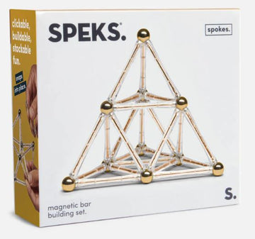 Speks: Spokes Gold is a magnetic bar building set, featuring a pyramid structure made of shiny bars and gold spheres. The packaging promotes clickable, buildable, and stackable fun, showcasing a hand assembling the magnetic pieces.