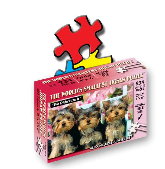 The World's Smallest Puzzle titled 'We Didn't Do It' featuring a box that displays three Yorkshire Terrier puppies against a floral background. The puzzle consists of 234 die-cut pieces and includes a pair of tweezers for assembly. The box dimensions are 4 x 6 inches, emphasizing its compact size.
