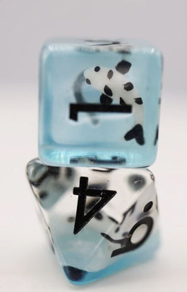A close-up of two colorful RPG dice from the Lucky Koi Fish RPG Dice Set by Foam Brain Games. The dice are transparent with a blue tint, featuring black numbers and patterns, including an image of a koi fish embedded within one die. The design combines traditional gaming elements with playful motifs, making these dice perfect for tabletop role-playing games.