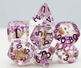 A set of seven RPG dice featuring a vibrant purple and clear design with embedded koi fish details. The polyhedral dice include various shapes like D20, D12, D10, D8, D6, D4, and a percentile die, all adorned with black numbers for easy readability, perfect for tabletop gaming enthusiasts.