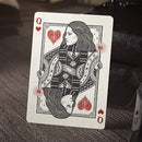 A high-quality playing card featuring the Queen of Hearts design. The card showcases a detailed illustration of a regal woman with flowing hair, holding a staff, adorned with intricate patterns and symbols. The background features decorative elements, emphasizing the card's classic and artistic style, suitable for collectors and card enthusiasts.