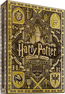 Harry Potter-themed playing cards packaging showcasing intricate designs featuring Hogwarts castle, house crests, and themed illustrations, primarily in yellow and gold colors. Crafted by Theory 11, this collectible deck is perfect for fans of the wizarding world.