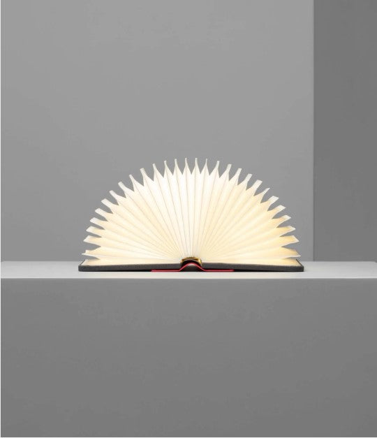 The Lito Mini Red/Gray Charging Book by Lumio, designed like an open book with fan-like pages illuminated from within, showcasing a unique aesthetic appeal.