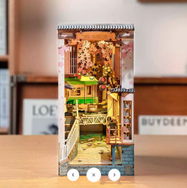 The Sakura Tram DIY Book Nook by Robotime features an intricately designed miniature scene showcasing a vibrant green tram amidst a blooming cherry blossom landscape. Perfect for creating a cozy nook display, this DIY kit offers an immersive building experience with detailed components, including railings, a bridge, and decorative elements inspired by Japanese culture.