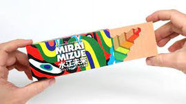 A colorful Mirai Mizue Flipbook box being held by two hands. The box features vibrant artwork with abstract designs in various colors, highlighting the playful nature of the flipbook experience. The package emphasizes creativity and entertainment.