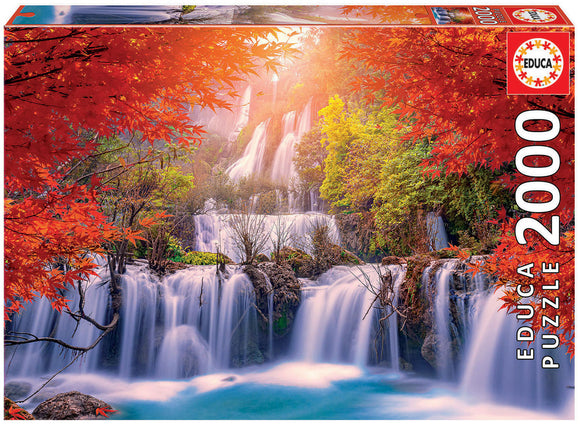 Box of the Waterfall in Thailand jigsaw puzzle from Educa, featuring a serene landscape of cascading waterfalls surrounded by vibrant red and green foliage under a soft golden light.
