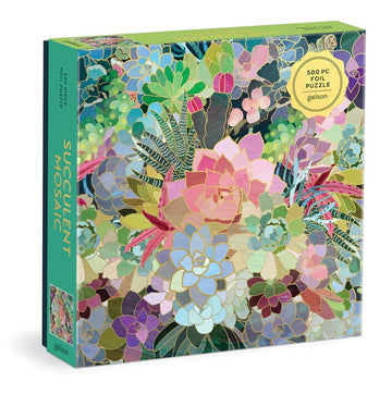 A 500-piece jigsaw puzzle titled 'Succulent Mosaic' by Galison. The puzzle features a vibrant, colorful array of succulents and tropical plants in a mosaic design, all adorned in shiny foil. The packaging is bright green with detailed illustrations and is designed to engage puzzle enthusiasts and nature lovers alike.
