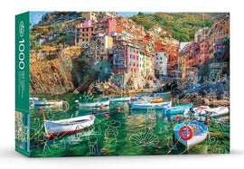 Jigsaw puzzle titled 'SPRING BREAK AT CINQUE TERRE' featuring a scenic view of colorful buildings along the coastline, with boats in the foreground and lush green hills in the background. The vibrant image is complemented by whimsical line drawings overlaying the picturesque landscape.