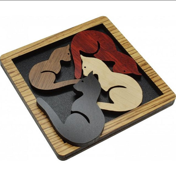 A wooden mechanical puzzle featuring four stylized cat shapes in various colors: brown, red, black, and white. The cats are intricately designed and fit together into a square frame made of light-colored wood, providing an engaging and challenging experience for puzzle enthusiasts.