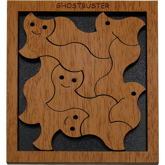 The Ghostbuster mechanical puzzle features playful ghost-shaped pieces crafted from smooth wood, each adorned with a smiling face. The puzzle is set within a dark background, showcasing the intricate design and craftsmanship. The top of the puzzle is engraved with the title 'GHOSTBUSTER', adding a whimsical touch to this engaging brain teaser.