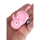 A small, pink wooden toy pig with a smiling face and black wheels, resting in a child's hand. The pig has felt ears and a yarn tail, designed as a pull-along toy, perfect for imaginative play.