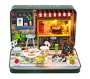 A colorful DIY summer theater kit in a tin from Guangzhou Hongda Craft Co., Ltd. The scene includes miniature furniture, detailed decorations, plants, and a lit up storefront, creating a charming cozy atmosphere for crafting and creativity.