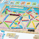 Close-up of the board game Ticket to Ride: San Francisco, featuring a colorful map of the city with train routes in various colors. Game components include train pieces in blue, purple, and pink, along with destination cards showcasing San Francisco attractions. The board displays vibrant graphics and details important game elements.