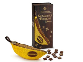 Bananagrams Signature Edition game featuring a banana-shaped pouch filled with letter tiles and a rectangular box showcasing the game name. The box has elegant gold detailing and a glossy finish, and the tiles display various letters.