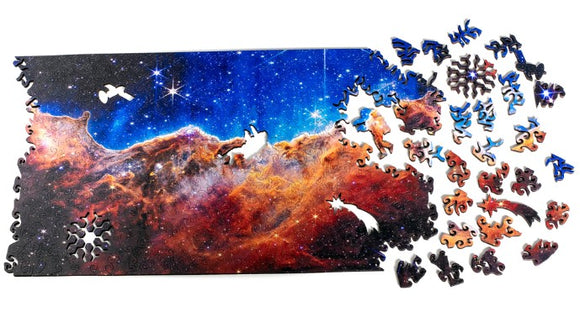 A vibrant jigsaw puzzle titled 'Cosmic Cliffs Infinite Galaxy' by Nervous System, featuring a stunning cosmic scene with swirling colors of deep blue, purple, and orange, showcasing stars and nebulae. Several puzzle pieces are scattered around the main image, highlighting the intricately designed celestial shapes.