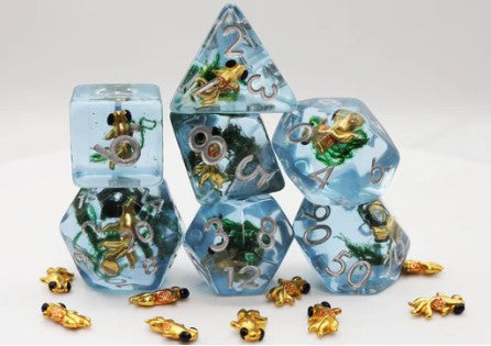A vibrant Goldfish RPG Dice Set by Foam Brain, featuring six polyhedral dice in clear resin infused with miniature goldfish and aquatic plants. The set includes a d20, d12, d10, d8, d6, and d4, each uniquely designed, with golden numbers for easy readability. This playful gaming accessory is perfect for RPG enthusiasts looking to enhance their gaming experience.