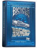A striking Bicycle playing card deck themed around 'Back to the Future.' The ornate box features a shiny silver finish with a blue background and images of the DeLorean time machine. The design includes the iconic 'Back to the Future' logo and text indicating air-cushion finish, highlighting its quality and crafting by US Playing Card Co.