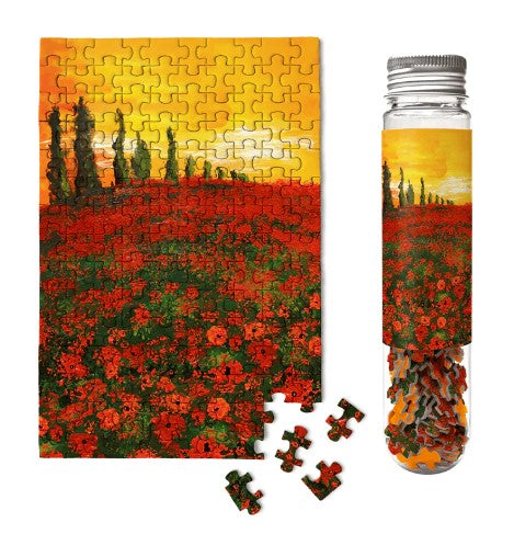 Serenity Micropuzzle by Micro Puzzle featuring a vibrant jigsaw design of a sunset over a field of red flowers, packaged in a stylish glass tube. Includes several loose pieces beside the puzzle.