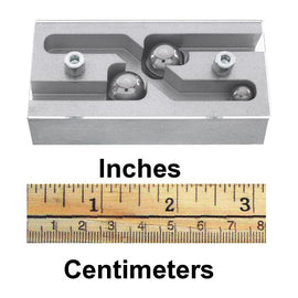 R2D2 Puzzle by Jean-Claude Constantin, featuring a mechanical design with three metallic balls positioned within a flowing maze structure. The product is displayed alongside a ruler indicating inches and centimeters for size reference.