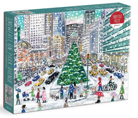 The packaging of 'Snowfall on Park Avenue' jigsaw puzzle by Michael Storrings, made by Galison. The illustration depicts a winter scene with pedestrians, a large decorated Christmas tree, snow, and iconic NYC buildings in the background.