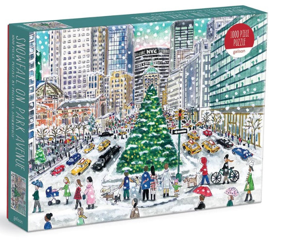 The packaging of 'Snowfall on Park Avenue' jigsaw puzzle by Michael Storrings, made by Galison. The illustration depicts a winter scene with pedestrians, a large decorated Christmas tree, snow, and iconic NYC buildings in the background.