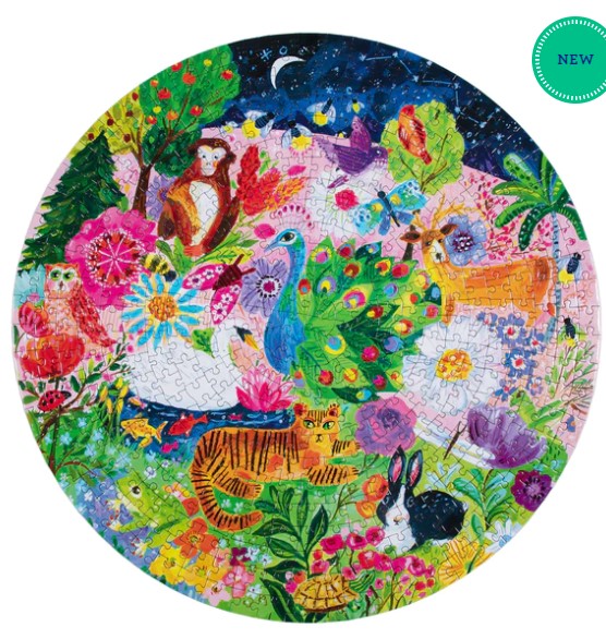 Colorful jigsaw puzzle titled 'Garden Sanctuary' by Eeboo, featuring a vibrant collection of animals and flowers in a lush garden setting. The round puzzle showcases playful depictions of a monkey, deer, peacock, tiger, rabbit, and various floral elements against a backdrop of lush greenery and a starry night sky.