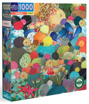 Eeboo's Pebbles jigsaw puzzle featuring a vibrant, colorful design with various shapes resembling pebbles and abstract forms. The puzzle box showcases a 1000-piece layout ideal for puzzle enthusiasts. It's made from recycled materials, emphasizing eco-friendliness.