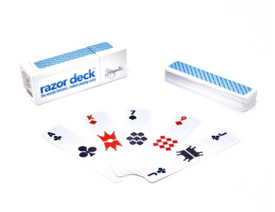 Razor deck playing cards by Storyastic, featuring a sleek design with classic card symbols including hearts, diamonds, clubs, and spades. The compact deck is shown fanned out with a protective box in the background, making it perfect for games and gatherings.