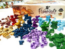 Flamecraft board game by Cardboard Academy Kickstarter featuring vibrant game pieces including colorful dragon miniatures, gems, and various tokens spread out beside the game box. The visual showcases a captivating collection of components designed for engaging gameplay.