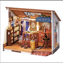 Kiki's Magic Emporium DIY kit featuring intricate wooden details, including a shelf filled with jars, a large wooden counter adorned with magical items, and decorative elements like a broom and a witch's hat. The charming emporium is designed to inspire creativity and imagination in crafting.