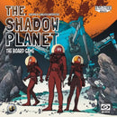 The Shadow Planet board game by Galakta features three astronauts in space suits standing on a rocky landscape. Behind them is a futuristic vehicle set against a vibrant orange planet. The title appears prominently at the top, with artwork showcasing a sci-fi theme and exploration elements.