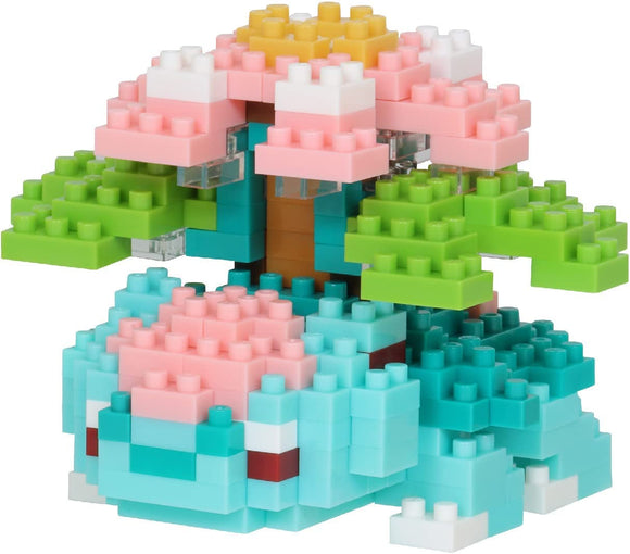 A colorful Nanoblock Mega Venusaur DIY kit showcasing a blocky representation of the Pokémon character. The model features vibrant shades of pink, blue, green, and yellow, with flower-like structures atop and leafy accents, making it an engaging construction toy for fans and builders alike.