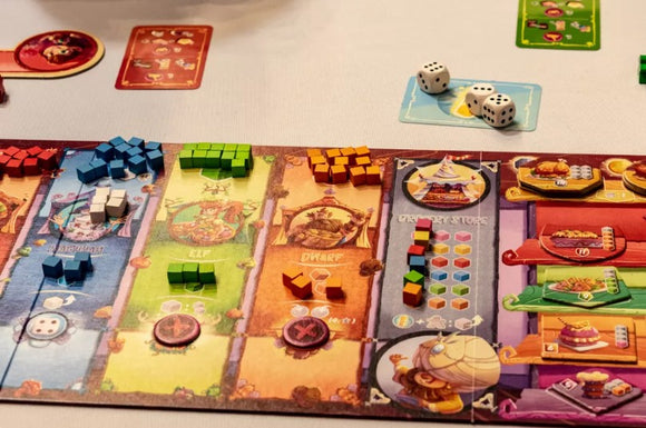 A colorful board game setup featuring various colored cubes, dice, and player cards spread across a game board. Players interact with game elements themed around fantasy characters and events.