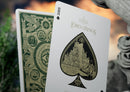A stunning Lord of the Rings card deck by Theory 11, featuring the Ace of Spades with intricate gold detailing, depicting a castle. The reverse side showcases an elaborate green design with iconic symbols from Middle-earth, including the eagle and the Eye of Sauron, emphasizing the epic fantasy theme.