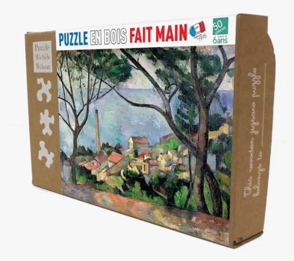 The Estaque View jigsaw puzzle by Wilson Jeux is a colorful wooden puzzle featuring a picturesque landscape of trees and seaside cottages. It comes in a cardboard box with a vibrant design, suitable for children aged 6 and up, containing 50 pieces for a fun and engaging activity.