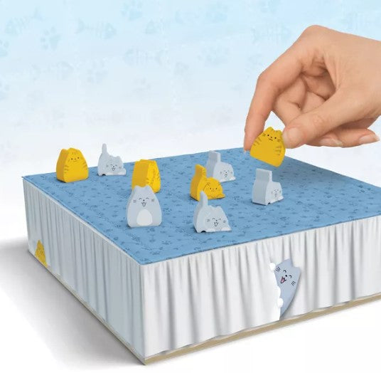 A hand reaching for a yellow cat-shaped piece in the game 'Boop.' by Smirk And Dagger. The game features a blue board with various cute, colorful animal pieces and a whimsical design.