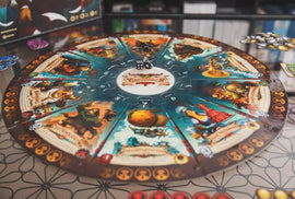 A vibrant board game titled 'Orconomics' from ARES GAMES. The circular game board features intricate illustrations and colorful tokens for player interaction. In the center, a pair of dice sits ready for gameplay. The outer rim showcases character cards and symbols associated with various game mechanics, perfect for strategy and fun.