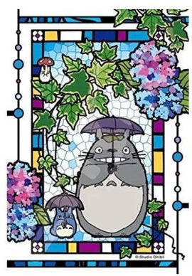 A beautifully designed crystal puzzle featuring Totoro surrounded by vibrant hydrangeas and ivy. The artwork emulates a stained glass window with rich colors, showcasing Totoro holding an umbrella alongside a smaller creature, depicting the whimsical and enchanting world of Studio Ghibli.