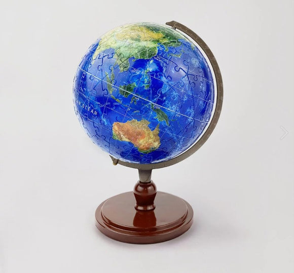 A 9-inch jigsaw puzzle globe titled 'Resplendent Earth' by Pintoo, featuring a vibrant blue and green map of the world. The globe is mounted on a classic brown wooden stand, showcasing detailed continent outlines and ocean names, perfect for educational fun and decor.