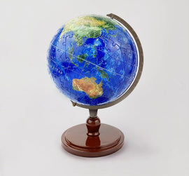 A 6-inch 3D jigsaw puzzle globe featuring beautifully detailed oceans and continents. The globe is displayed on a wooden stand, showcasing vibrant colors and intricate puzzle pieces that interlock to form a unique three-dimensional representation of the Earth. Perfect for educational purposes or as a decorative piece, this jigsaw puzzle offers a fun and engaging way to explore geography.