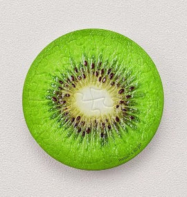 A round jigsaw puzzle magnet designed as a kiwi slice, displaying vibrant green and yellow colors with intricate seed details in the center. Perfect for puzzle enthusiasts and fruit lovers alike.