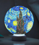 3D jigsaw puzzle light featuring Van Gogh's iconic 'Starry Night' design. The puzzle is illuminated from underneath, showcasing vibrant colors and intricate details. The globe shape adds a whimsical touch, making it a perfect decorative piece for any room.