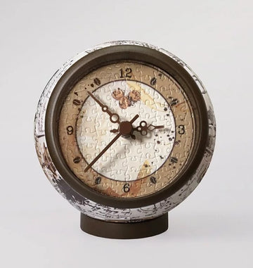 Manuscript Coffee 3D Jigsaw Puzzle Clock by Pintoo. This unique jigsaw puzzle features a clock design with intricate puzzle pieces forming the clock face, showcasing a blend of artistic details in earth tones. Perfect for puzzle enthusiasts and home decor lovers.